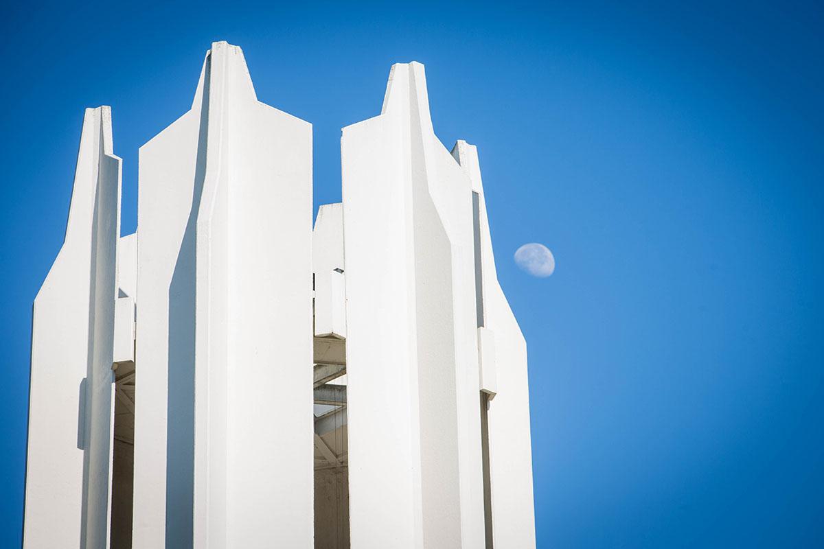 The Memorial Bell Tower stands against a blue sky on a fall morning.