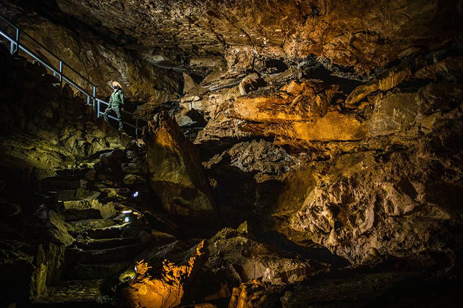 布雷特·朗在俄勒冈洞穴内的一个楼梯上旅行, 它的特色是令人惊叹的岩层，这些岩层是一百多年前雨水从西斯基尤山脉的森林土壤中渗透出来的，形成了世界上为数不多的大理石洞穴之一.